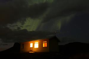 Sunset Cottage- Northern lights dancing on the sky above the cottage.