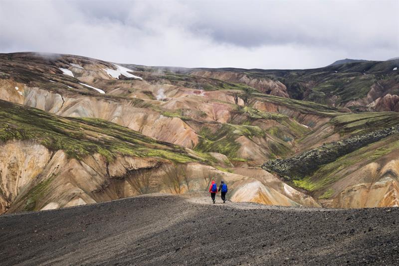 Couple exploring the colourful mountains of Landmannalaugar in Iceland