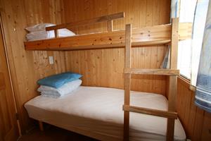 The bedroom of the three person cottage has a bunk bed and a double bed
